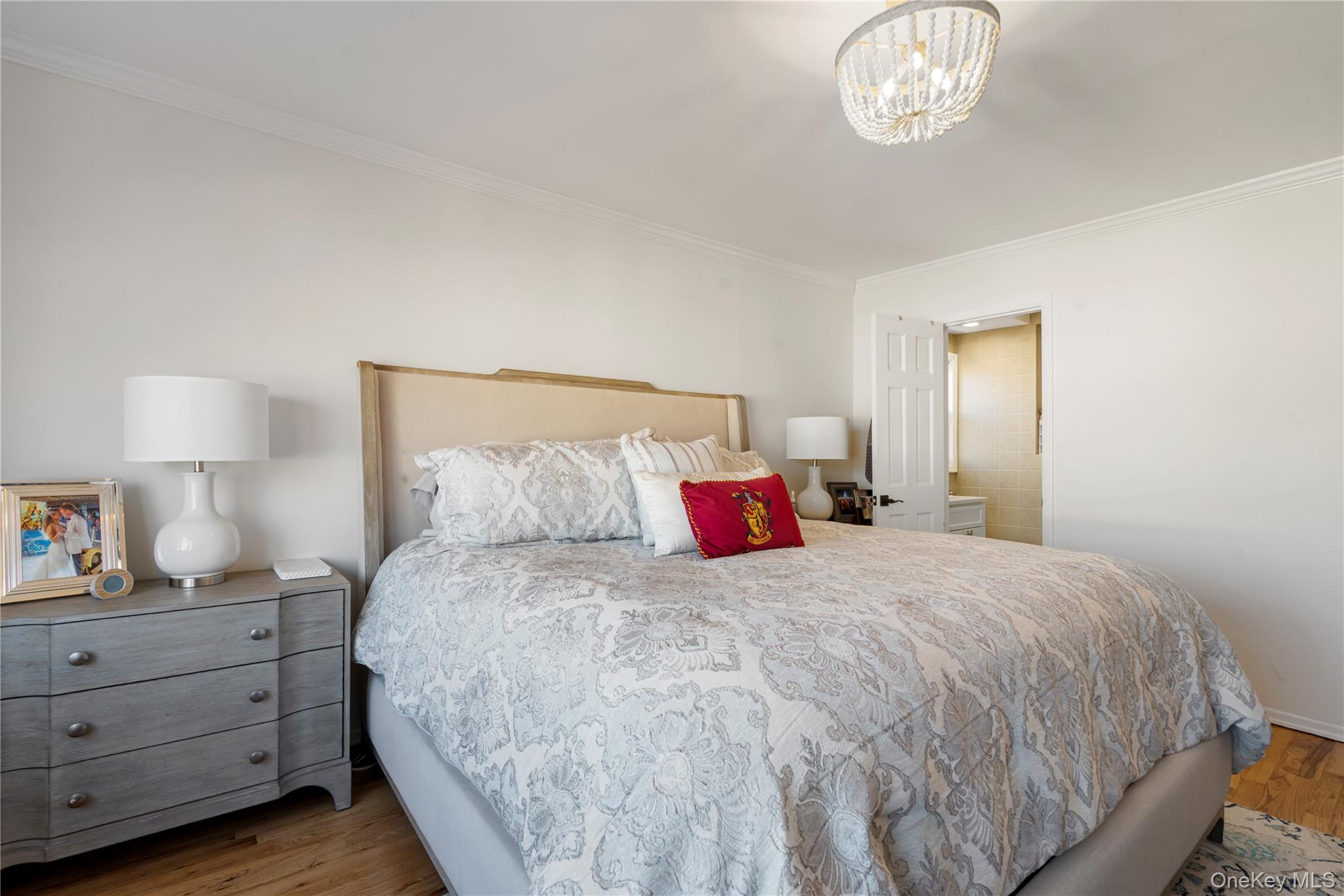 208-48 15th Road, Unit 2 Queens, NY 11360 - Photo 18 of 23 Bedroom featuring wood finished floors, crown molding, and a chandelier