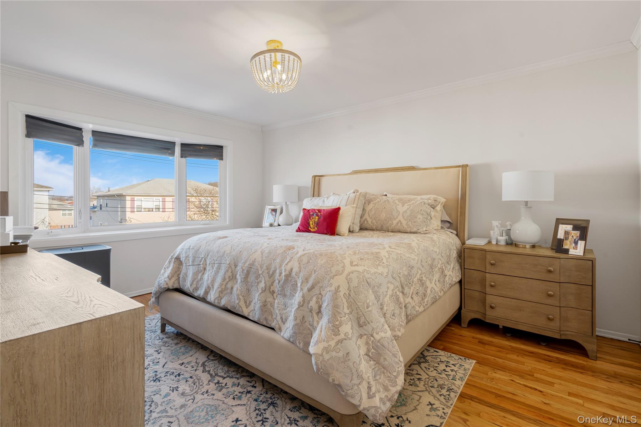 208-48 15th Road, Unit 2 Queens, NY 11360 - Photo 19 of 23 Bedroom with light wood-style floors, crown molding, and a chandelier