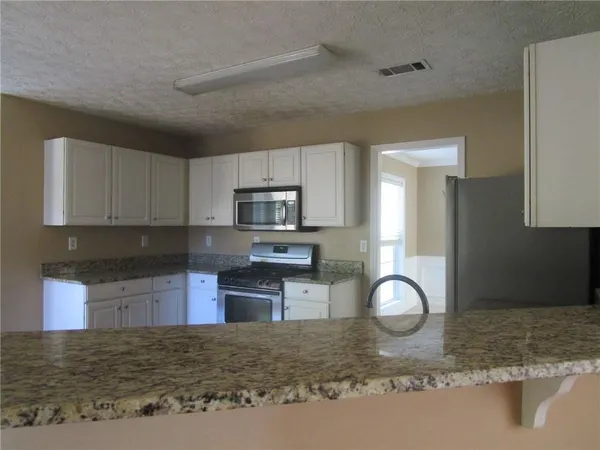 a kitchen with stainless steel appliances granite countertop a stove sink and cabinets