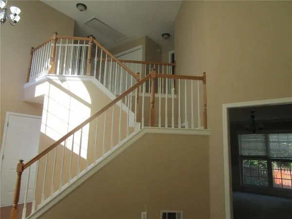 a view of staircase with lots of frames on wall and a window