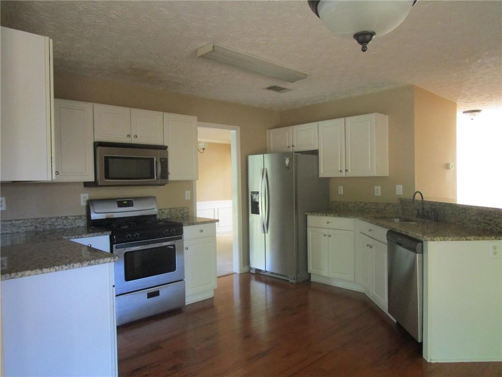 2825 Factor Walk Boulevard Suwanee, GA 30024 - Photo 5 of 25 a kitchen with granite countertop a refrigerator stove and microwave