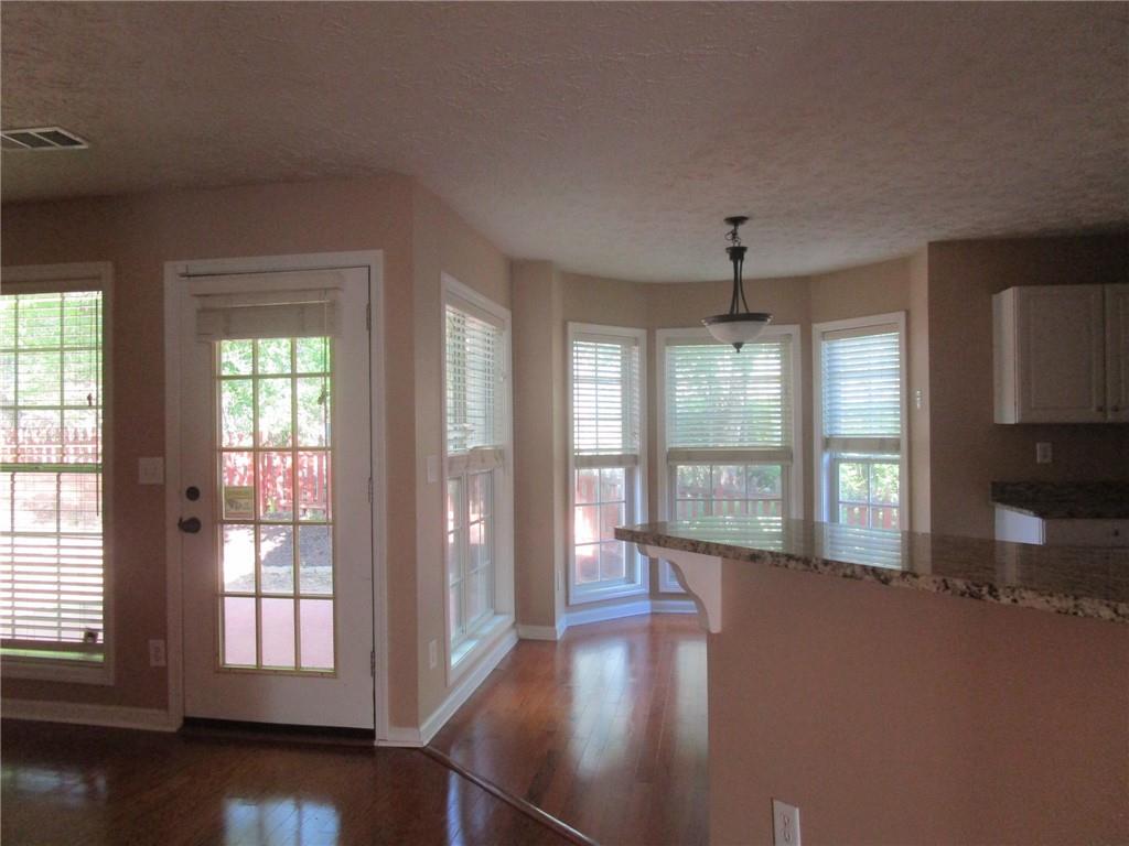 2825 Factor Walk Boulevard Suwanee, GA 30024 - Photo 6 of 25 an empty room with wooden floor and windows