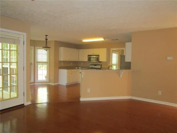 a view of empty room with wooden floor and windows