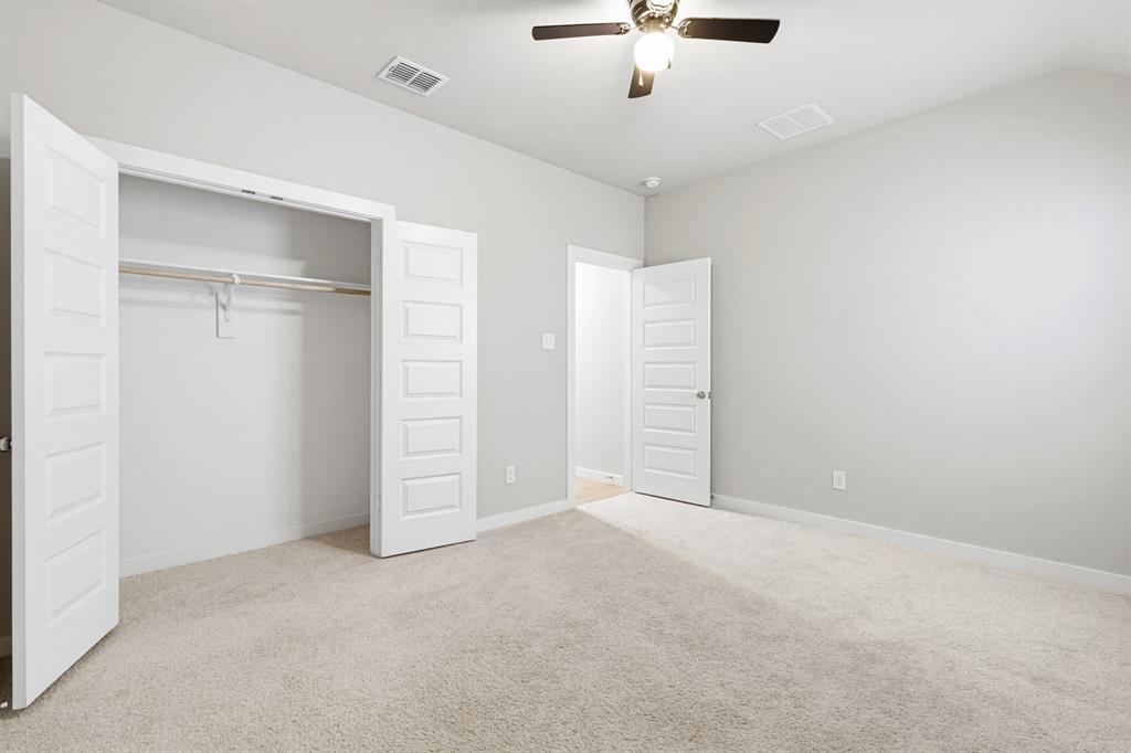 2108 Mossfield Lane Forney, TX 75126 - Photo 23 of 28 Carpeted interior room featuring light gray walls, white trim, a ceiling fan with integrated lighting, and a closet with bifold doors