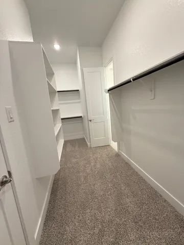 a view of walk in closet with empty racks