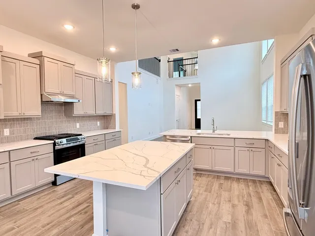 a kitchen with granite countertop white cabinets and white appliances