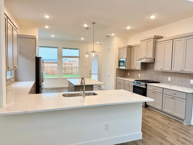 a kitchen with stainless steel appliances kitchen island granite countertop a sink and cabinets