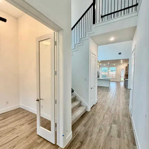 a view of a hallway with wooden floor and staircase