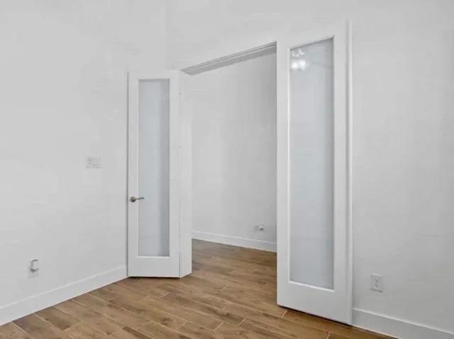 a view of an empty room with wooden floor