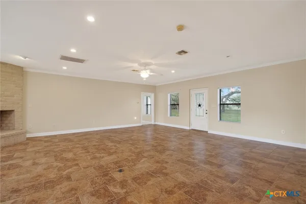 an empty room with windows and fan