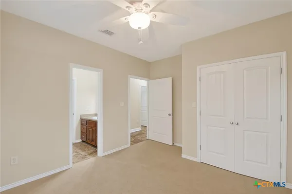 a view of an empty room with wooden floor and door