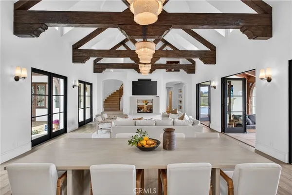 a view of a dining room with furniture a chandelier and wooden floor