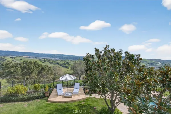 a living room with patio furniture and a potted plant