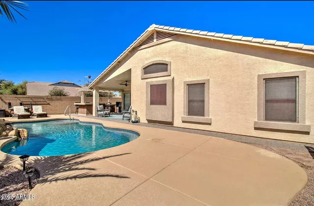 a view of a house with pool and chairs