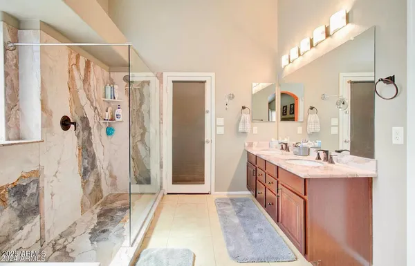 a bathroom with a double vanity sink mirror and shower