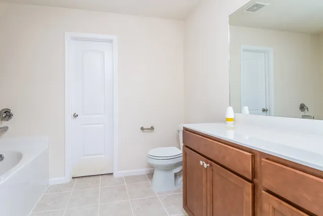 a bathroom with a granite countertop sink a toilet and bathtub