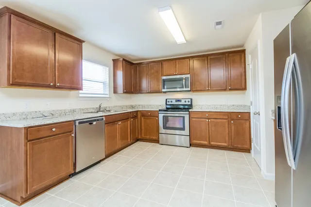 a kitchen with stainless steel appliances granite countertop a stove top oven a sink and dishwasher