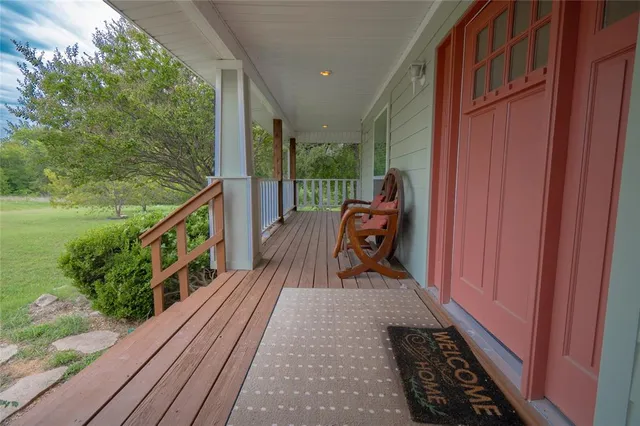 a balcony with wooden floor and outdoor seating
