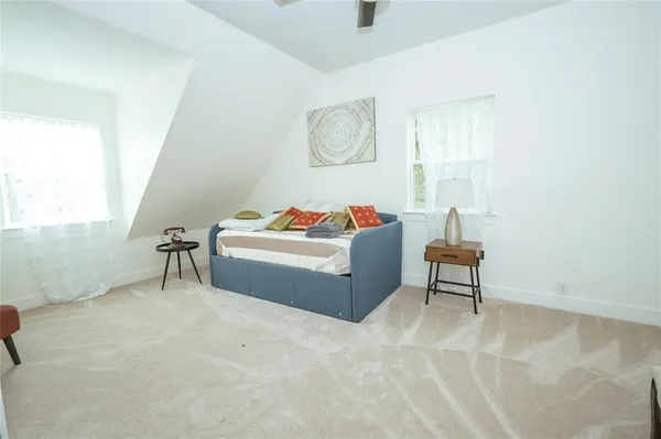 a view of a kitchen with kitchen island a large counter top space a sink stainless steel appliances and windows