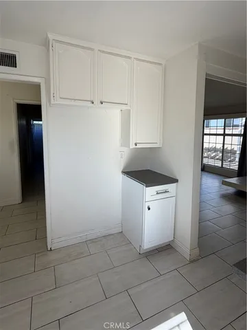 a kitchen with a stove cabinets and utility room