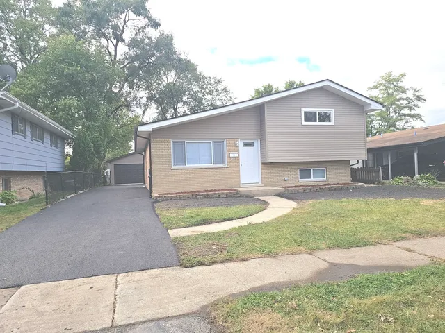 a view of a house with a yard and garage