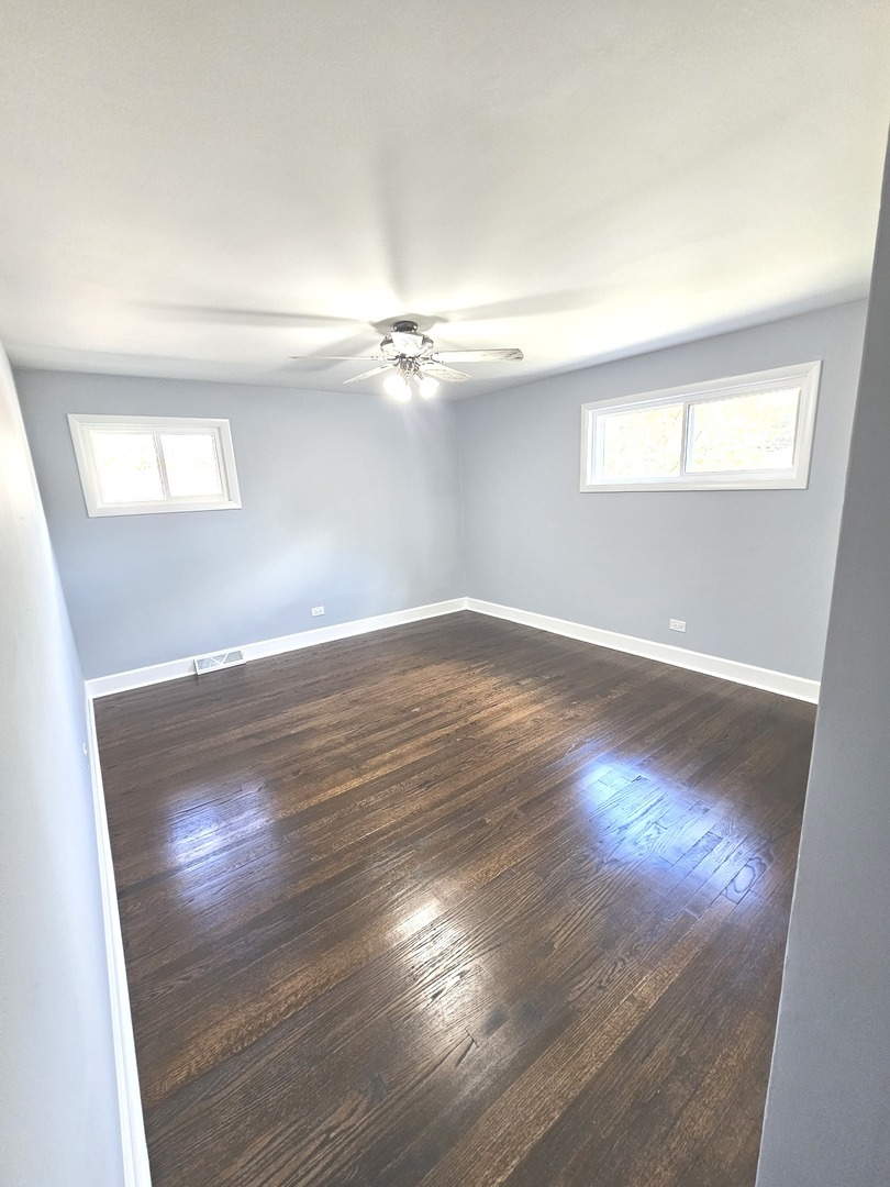14926 Kenton Avenue Midlothian, IL 60445 - Photo 12 of 20 an empty room with wooden floor and windows