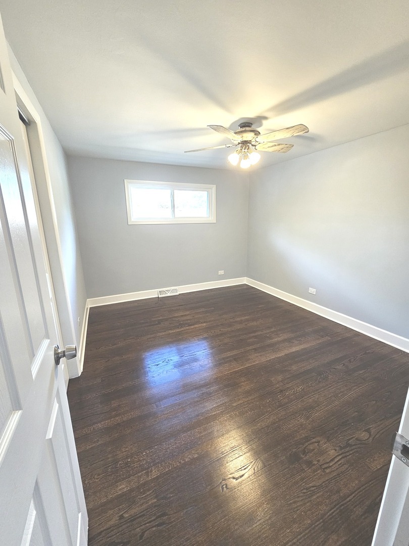 14926 Kenton Avenue Midlothian, IL 60445 - Photo 13 of 20 wooden floor in an empty room with a window