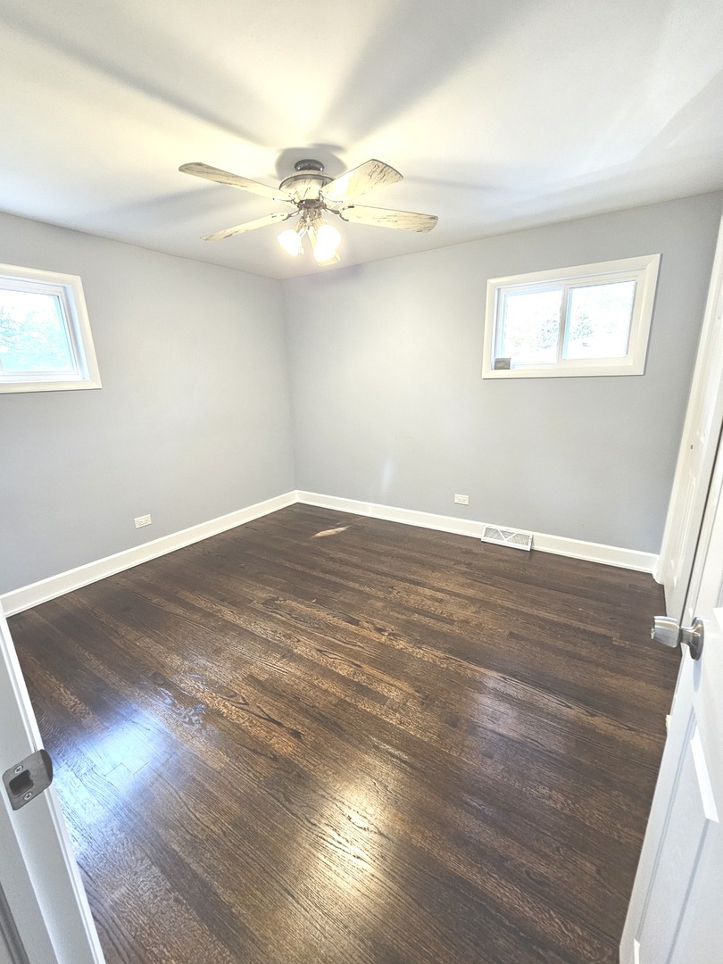 14926 Kenton Avenue Midlothian, IL 60445 - Photo 14 of 20 an empty room with wooden floor fan and windows