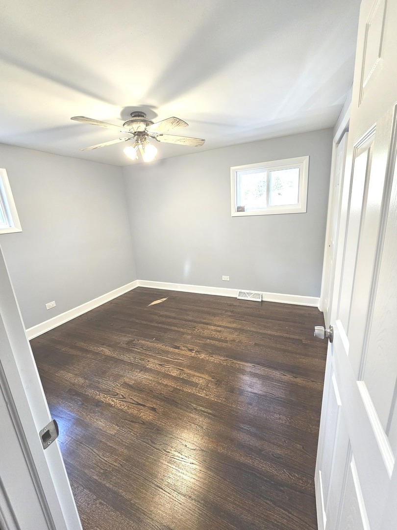 14926 Kenton Avenue Midlothian, IL 60445 - Photo 16 of 20 an empty room with wooden floor fan and windows