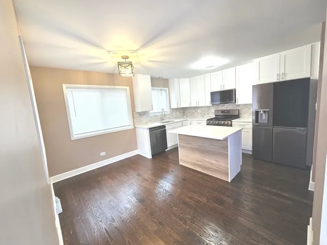 a kitchen with a refrigerator and a stove top oven