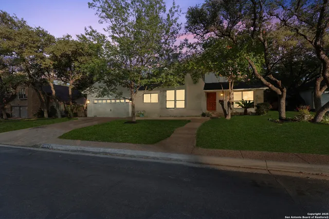 a front view of a house with a garden and trees