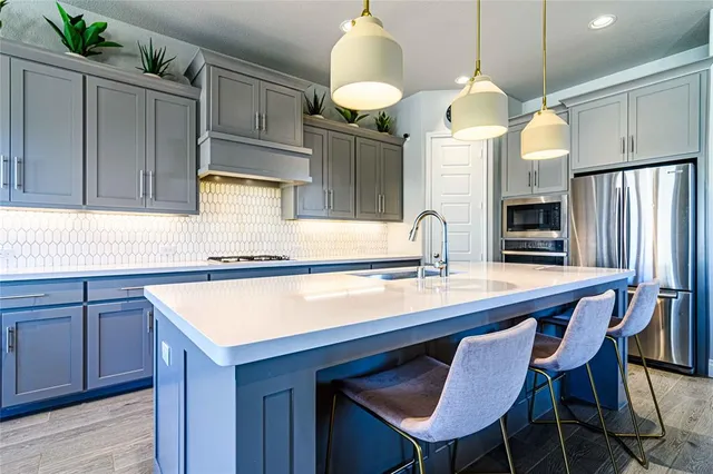 a kitchen with a table chairs refrigerator and microwave
