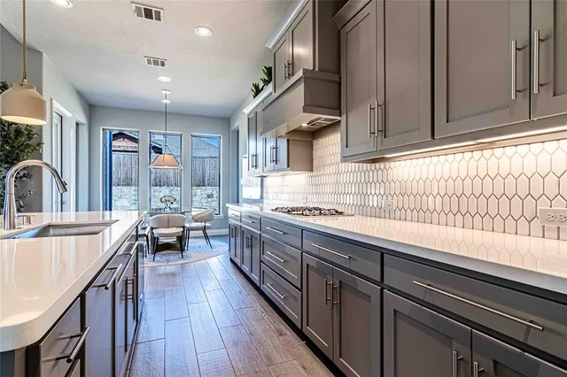 a kitchen with stainless steel appliances a sink stove and cabinets