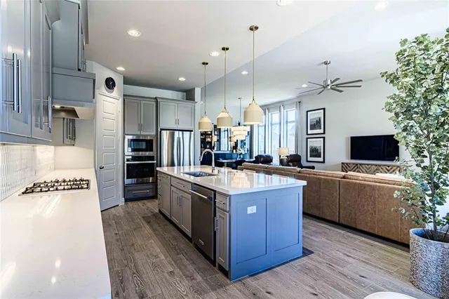 a kitchen with kitchen island granite countertop a sink stove and refrigerator