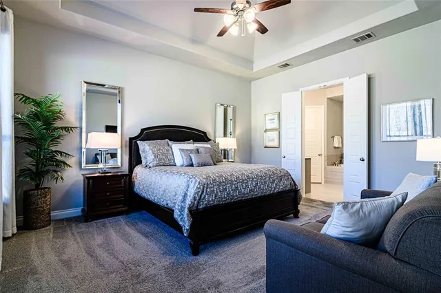 a bedroom with a bed couch and potted plant