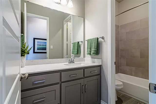 a bathroom with a granite countertop sink toilet a large mirror a bathtub and shower