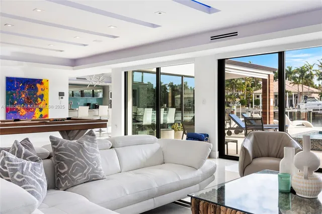 a dining room with furniture large windows and wooden floor