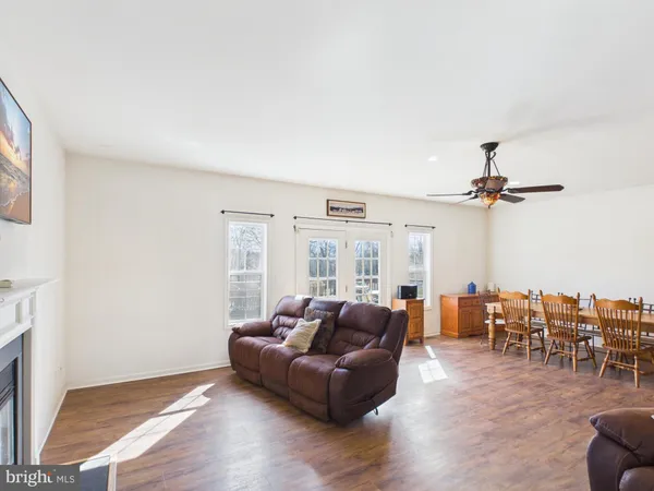 a living room with furniture kitchen view and a large window