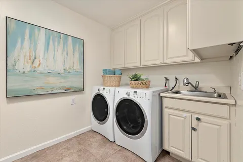 a utility room with sink dryer and washer