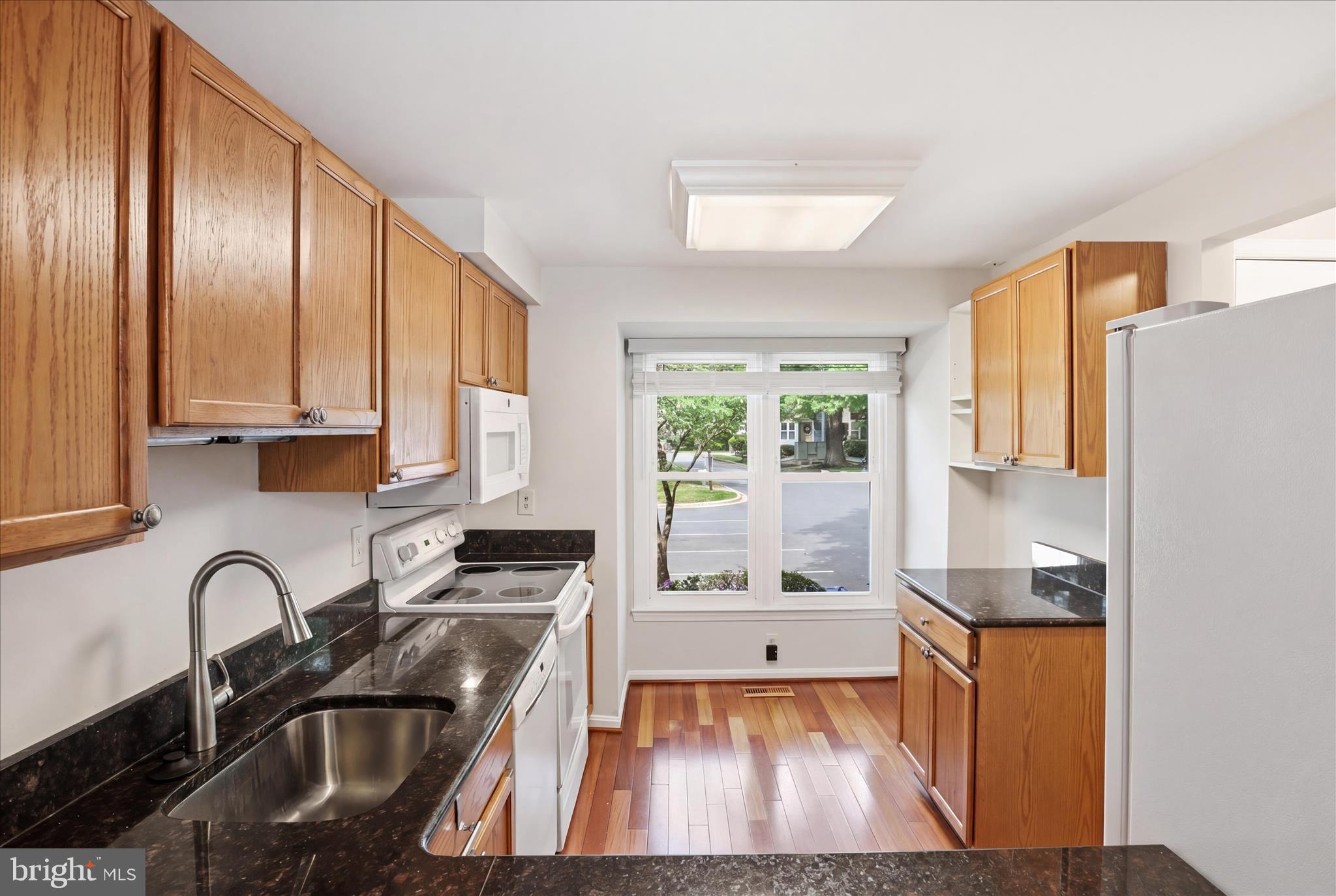 1773 Whisperhill Drive Reston, VA 20194 - Photo 16 of 51 a kitchen with granite countertop a stove a sink and a refrigerator