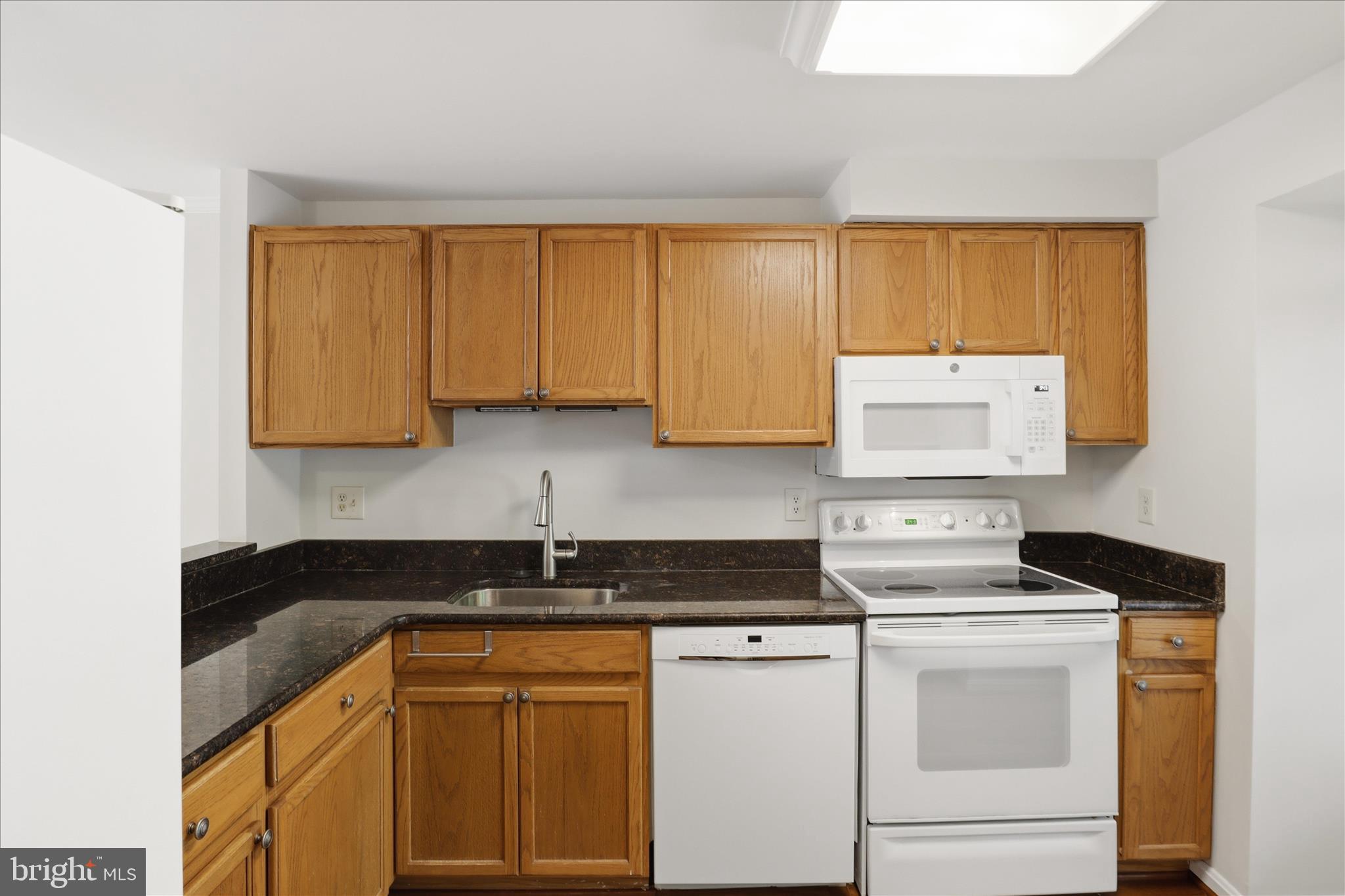 1773 Whisperhill Drive Reston, VA 20194 - Photo 17 of 51 a kitchen with granite countertop white cabinets and white appliances