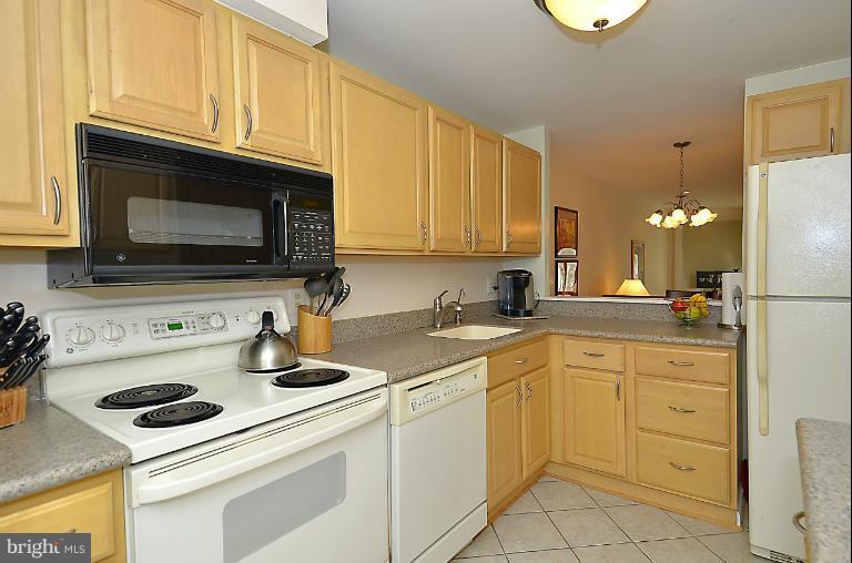 1688 Oaktree Court Reston, VA 20194 - Photo 13 of 23 a kitchen with cabinets appliances a sink and a counter top space