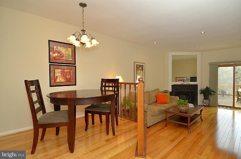 1688 Oaktree Court Reston, VA 20194 - Photo 18 of 23 a living room with dining table and a wooden floor