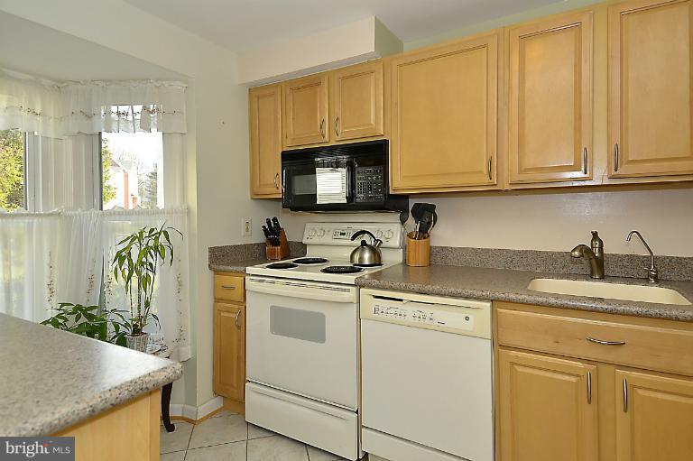 1688 Oaktree Court Reston, VA 20194 - Photo 5 of 23 a kitchen with granite countertop white cabinets and white appliances