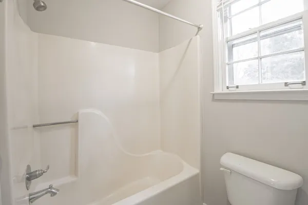 a white bath tub sitting next to a toilet