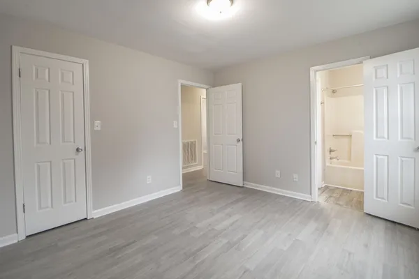 an empty room with wooden floor & windows