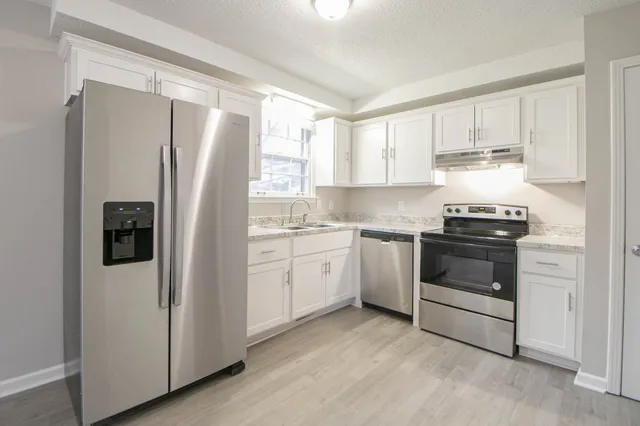 a kitchen with a refrigerator sink and cabinets