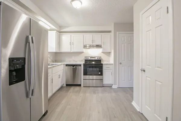 a kitchen with stainless steel appliances a refrigerator and a stove top oven
