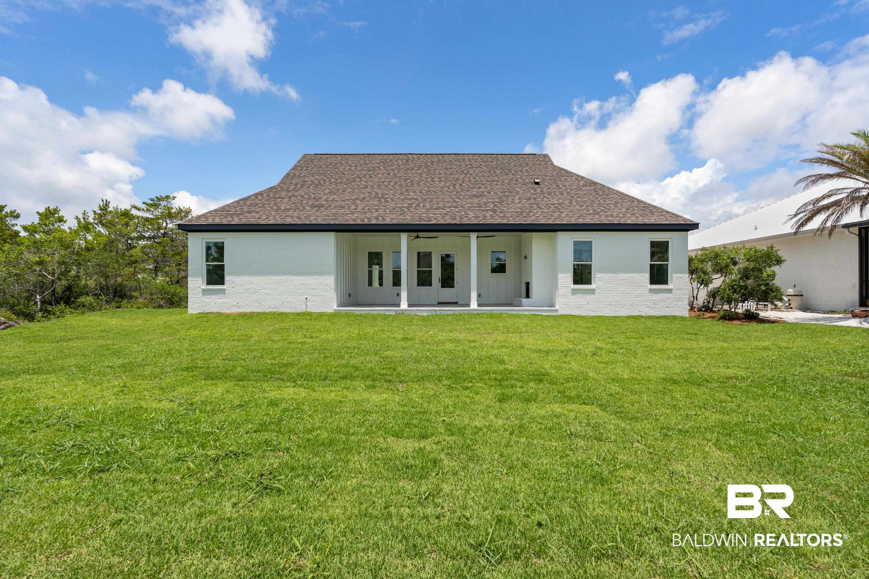 30650 Ono N Loop West Orange Beach, AL 36561 - Photo 35 of 38 Rear view of house featuring ceiling fan, a yard, and a shingled roof