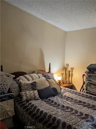 a bed sitting in a bedroom next to a lamp